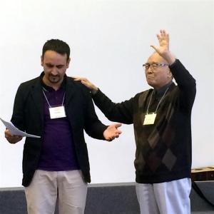 Pastor Wang prays for Ionel Cocos, Roma leader from Romania